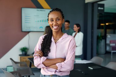 Modern konferans salonunda silah omuza duran neşeli, genç siyahi iş kadını.