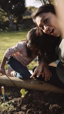Çoklu etnik kökenli Asyalı bir anne kızıyla bahçıvanlık yapıyor. Yüksek kaliteli FullHD görüntüler