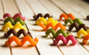 tahta bir masanın üzerinde yatan çok renkli makarna