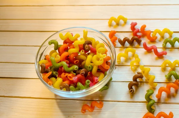 Mångfärgade pasta liggande på ett träbord — Stockfoto