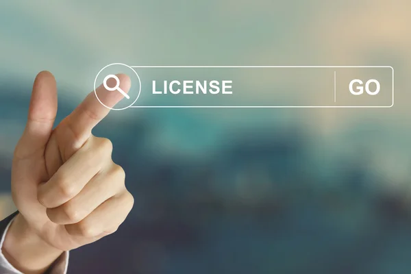 Business hand clicking license button on search toolbar — Stock Photo, Image