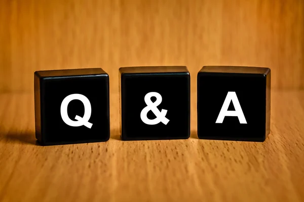 Q & A or Questions and answers word on black block — стоковое фото