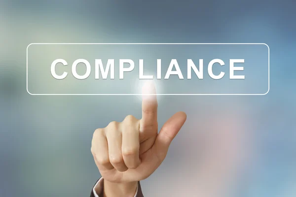 Business hand clicking compliance button on blurred background — Stock Photo, Image