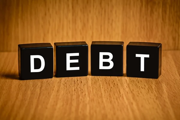 Financial interest bearing debt word on black block — Stock Photo, Image