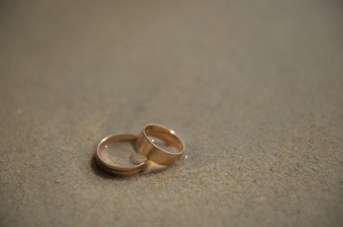 wedding rings on sea sand washed by the waves clipart