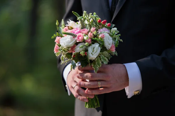 Мужские руки со свадебным букетом — стоковое фото