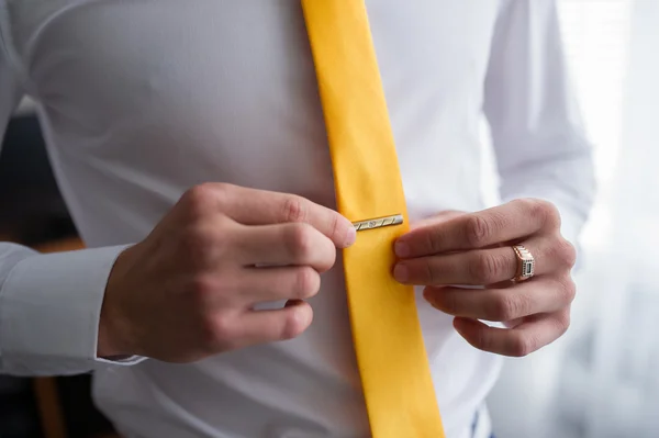 bir adam Sarı kravat bağlar