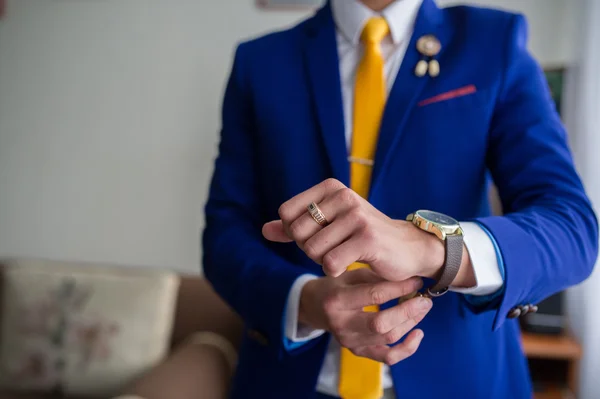 De man in de blauwe pak draagt horloges — Stockfoto