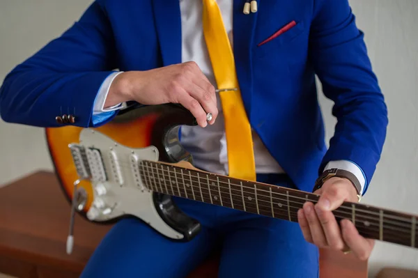 ceketli adamı gitar çalıyor