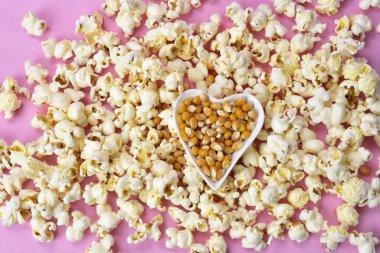 Pembe arka planda yukarıdan izlenen sıcak patlamış mısır. Üst Manzara. Girişim konsepti