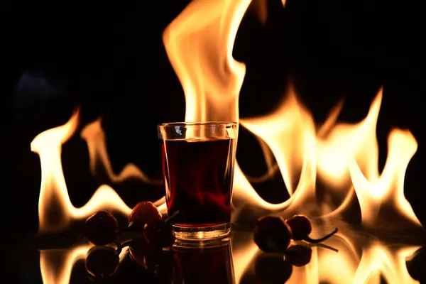 Rood Drankje Met Vuur Achter Reflectie Zwarte Achtergrond — Stockfoto