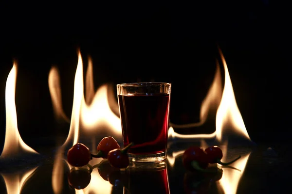 Rood Drankje Met Vuur Achter Reflectie Zwarte Achtergrond — Stockfoto