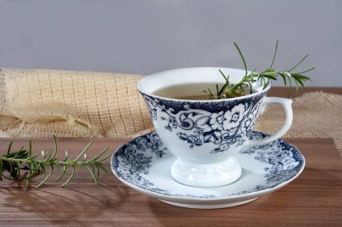 Tahta bir paspasın üzerinde bir fincan ferahlatıcı yeşil