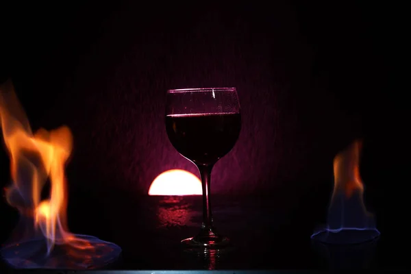 Glas Rode Wijn Glazen Tafel Met Vuur Eromheen Zwarte Achtergrond — Stockfoto