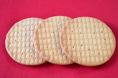 Kırmızı arkaplanda izole edilmiş yuvarlak gofret. İzole edilmiş kuru kraker kurabiyeleri. İzole edilmiş tuzlu atıştırmalıklar..