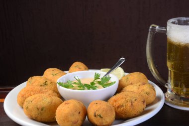 Bulanık arka planda masada sebze soslu lezzetli kızarmış morina köftesi..