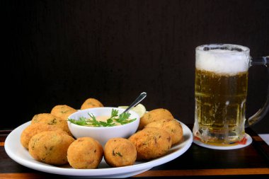 Bulanık arka planda masada sebze soslu lezzetli kızarmış morina köftesi..