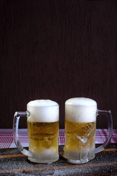 黒っぽい背景のテーブルの上に超冷たくさわやかな生ビールのおいしいマグカップ — ストック写真