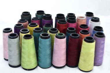 Beyaz arkaplanlı birkaç makara dikiş ipliği