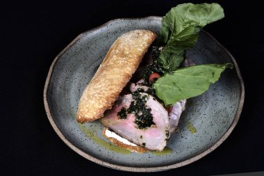 Rucula, vişneli domates ve pesto soslu etli sandviç.