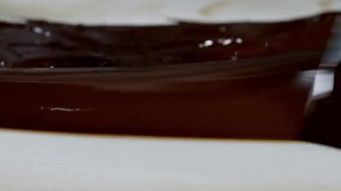 Erimiş çikolatayı doğal taşın üzerinde ısıtmak. Kadın eli ve spatula yakın plan..