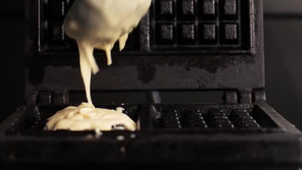 Filmato di versare un impasto su una piastra per cialde. preparare un waffle — Video Stock