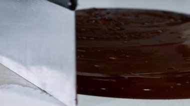 Erimiş çikolatayı doğal taşın üzerinde ısıtmak. Kadın eli ve spatula yakın plan..