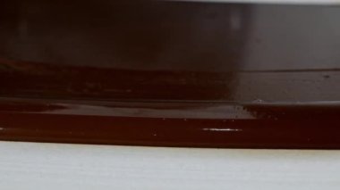 Erimiş çikolatayı doğal taşın üzerinde ısıtmak. Kadın eli ve spatula yakın plan..