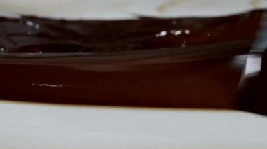 Erimiş çikolatayı doğal taşın üzerinde ısıtmak. Kadın eli ve spatula yakın plan..