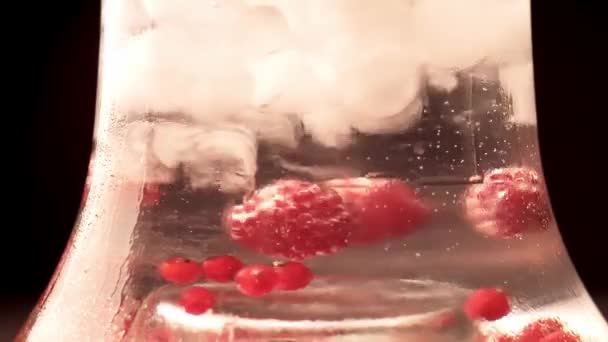 Close up of glass transparent flask of hookah with ice and raspberry — Stock Video