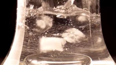 Soğutulmuş suyla şeffaf kase. Buz küpleri suya atılır.