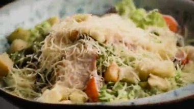 Lezzetli taze sezar salatası siyah bir masada döner.