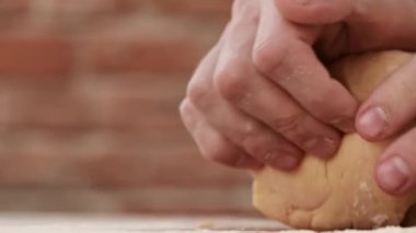 Makarna hamuru yapan adama yakın çekim. Şef hamur yoğuruyor.