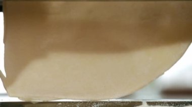 Makarna makinesinden taze hamur geliyor, yakın plan. Geleneksel İtalyan ev yapımı makarna hamuru kesmek için makinede yapılıyor. 