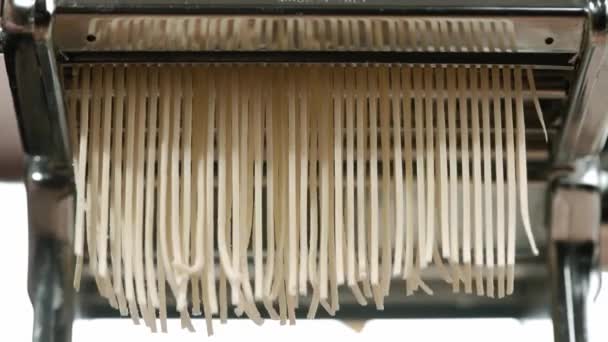 Pâtes maison italiennes traditionnelles fabriquées sur machine pour couper la pâte. Pâtes spaghetti fraîches sortant de la machine à pâtes, gros plan. Chef utiliser machine de découpe de pâtes — Video