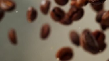 Yavaş çekim, kızarmış kahve çekirdeği gradyan grisi üzerinde..