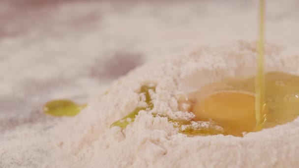 Olja rinner ner på mjöl och rå äggula. Häll olivolja i mjölet med. Göra pasta deg. — Stockvideo