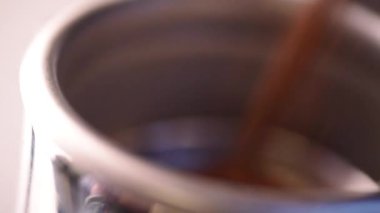 Kavrulmuş kahve çekirdekleri, kahve makinesinin içine kahve öğütücüsünden serpilmiş.