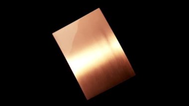 Siyah arka planda dönen soyut desenli izole metal plaka. Bakır plaka üzerindeki soyut yansıma