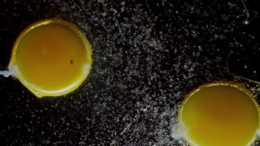 Kırık bir tavuk yumurtasına şeker damlaları yavaşça düşer.