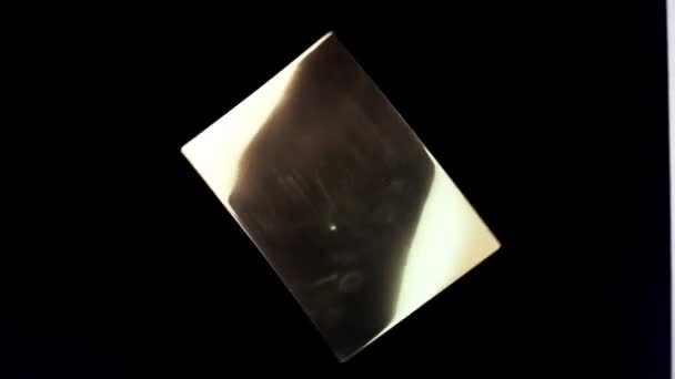 Isolierte Metallplatte mit abstrakter Textur, die auf schwarzem Hintergrund rotiert. Abstrakte Reflexion auf Kupferplatte — Stockvideo