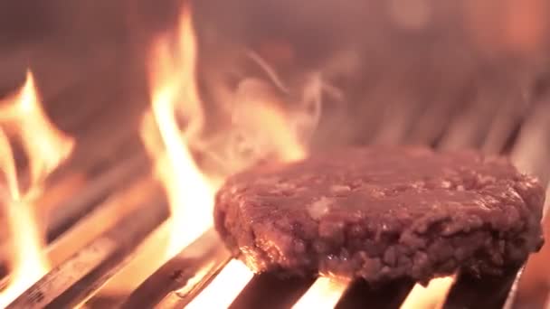 Pečení šťavnatý burger s kořením a bylinkami v hořících dřevěných uhlíků oheň na bbq mřížce, plameny a kouř ve zpomaleném filmu. . Gril na grilu — Stock video