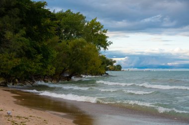 Gün batımında Michigan Gölü kıyısında deniz feneri kumsalı. Evanston, Illinois, ABD
