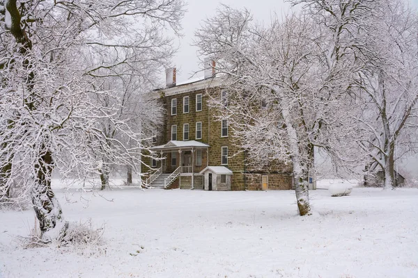 Karlı bir sabahta Midwest kırsalında eski bir taş otel. LaSalle County, Illinois, ABD