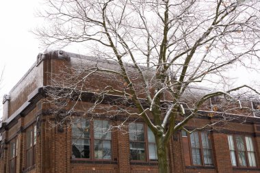 Karla kaplı ağaç ve eski tuğla bina. Peru, Illinois, ABD