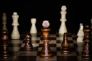 Tahta satranç tahtası ve siyah arka planı olan parçalar..