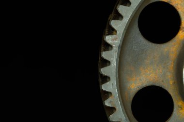 Siyah arkaplan ile kısmen paslanmış dişli.