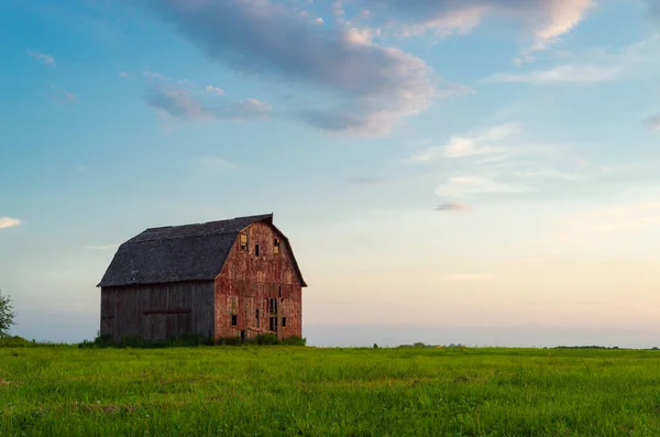 Illinois kırsalında gün batımında eski bir kırmızı ahır. LaSalle County, Illinois, ABD