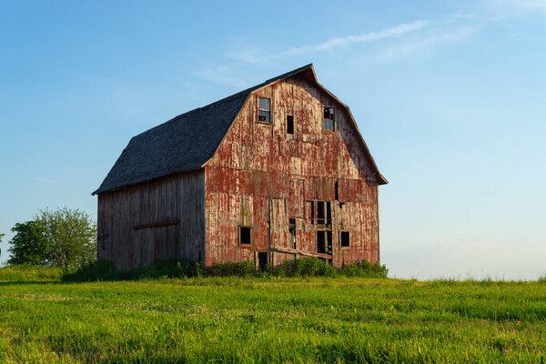 Старый красный амбар в сельской местности Иллинойса на закате. Округ Ла-Сад, штат Иллинойс, США