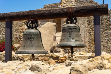 San Juan Capistrano, Kaliforniya - ABD - 9 Temmuz 2021: Arka planda tarihi San Juan Capistrano Misyonu kalıntıları olan orijinal çanlar.